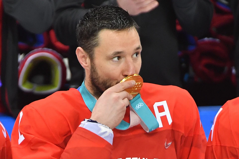 Илья Ковальчук целует золотую олимпийскую медаль.