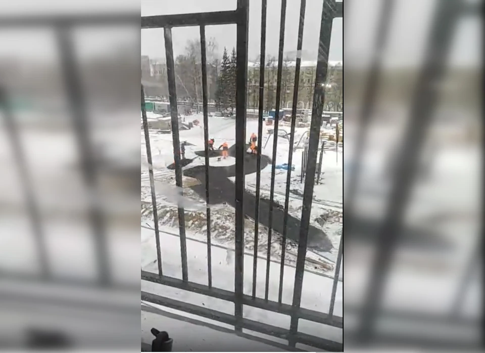 Рабочих не смутило, что они укладывают асфальт на снег. Стоп-кадр с видео Станислава Кайгородова.