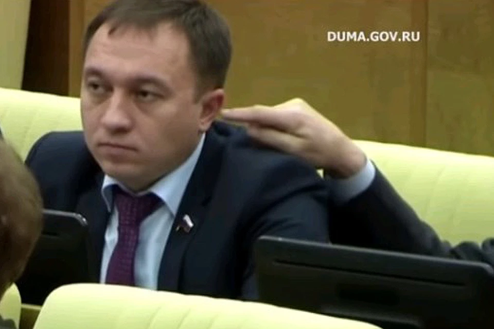 Депутат Юрий Петров своеобразно развлекся на заседании госдумы, потрогав пальцем ухо своего соседа - Олега Быкова (на фото).