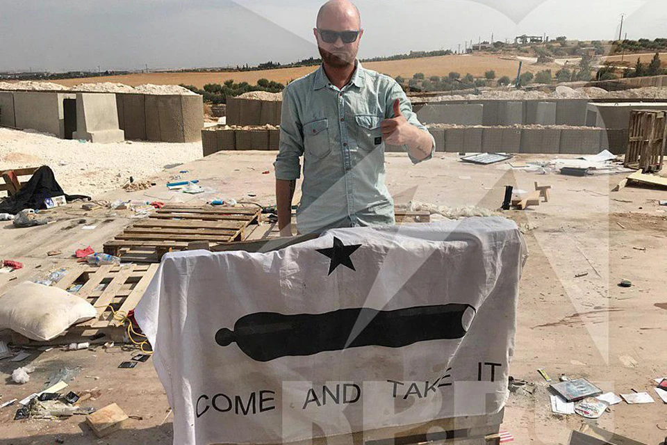 Александр Коц с флагом, на котором написан девиз Центрального командования специальными операциями США - "Приди и возьми"