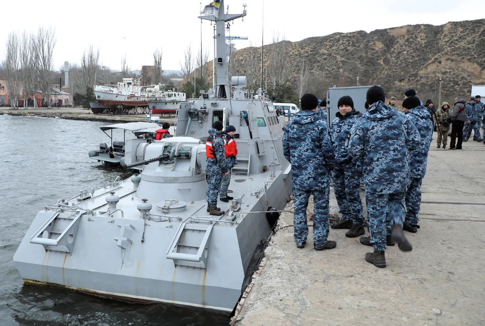 Украинские военные у возвращенного Россией катера в порту города Очаков.