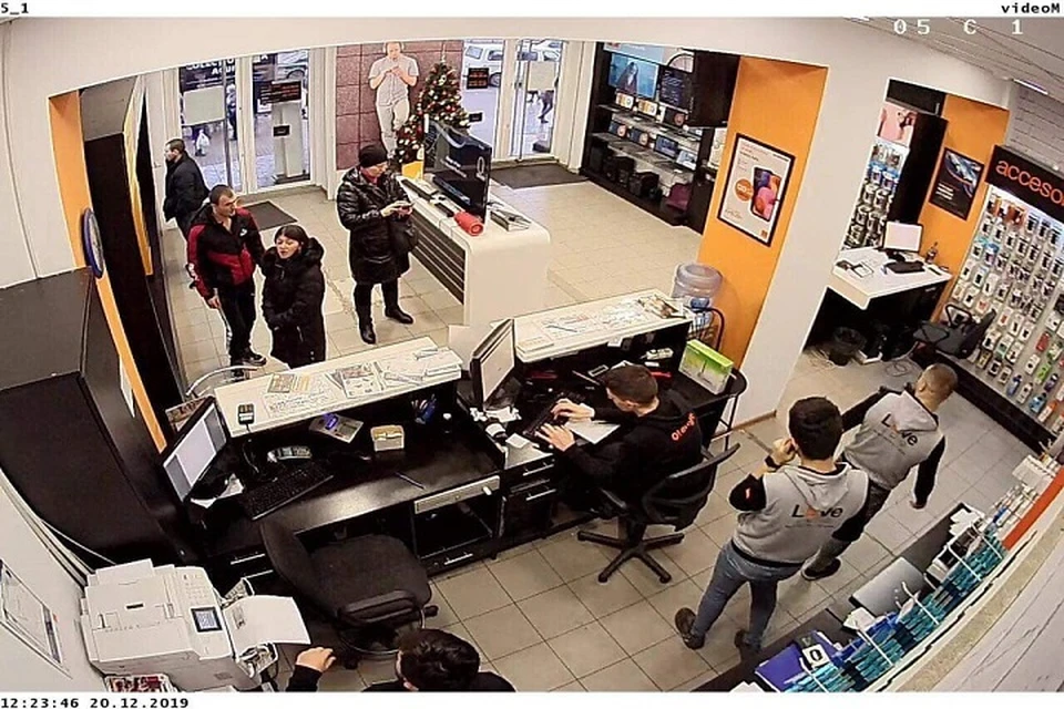 Человек, который увез Регину и она сама (крайние слева) - в магазине, торгующими гаджетами (Фото: кадр с камеры видеонаблюдения).