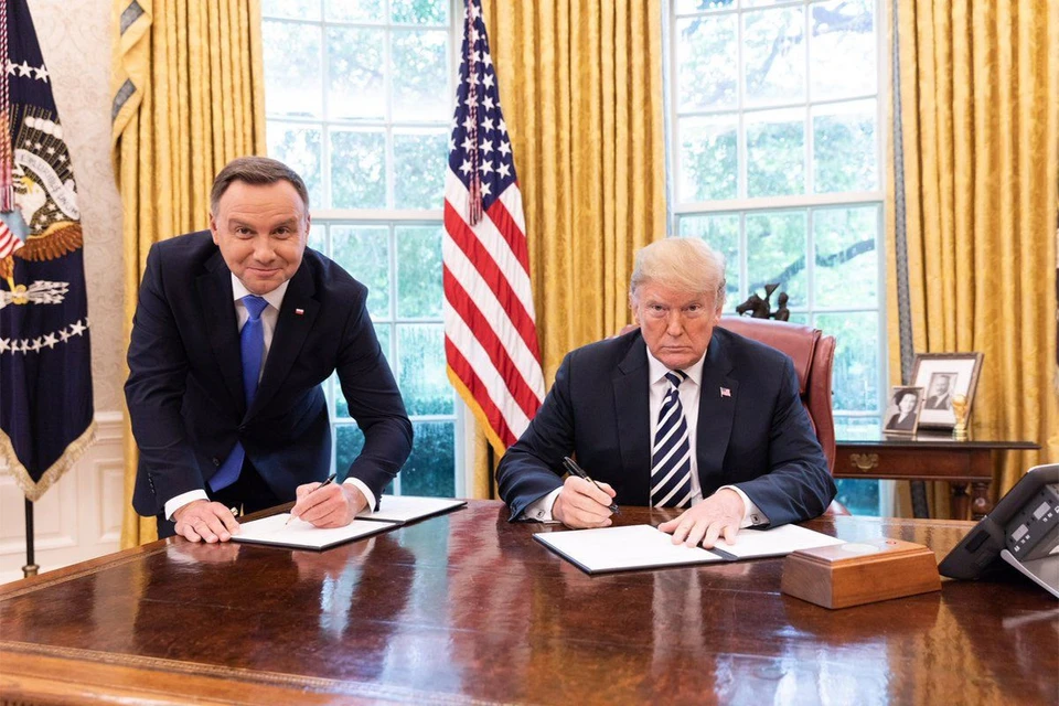 Знаменитое фото из Белого дома, на котором Трамп по-хозяйски подписывает документ сидя, а президент Польши охотно проявляет гибкость "партнера по НАТО". Фото: пресс-служба Белого дома