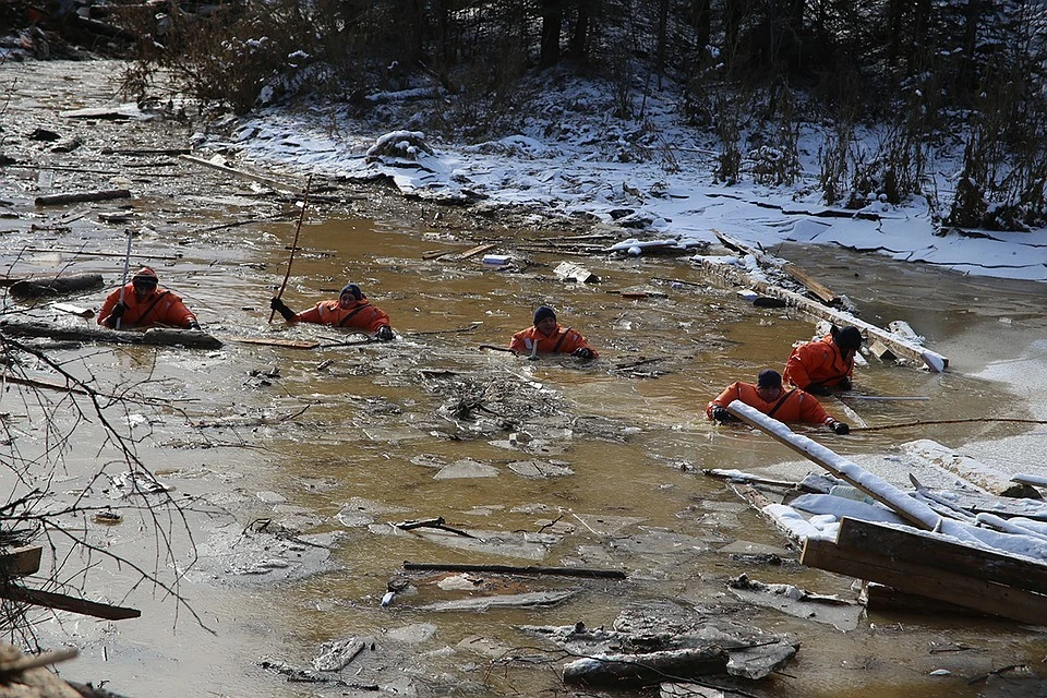 Спасатели искали пропавших при прорыве дамб золотодобытчиков по горло в ледяной воде.