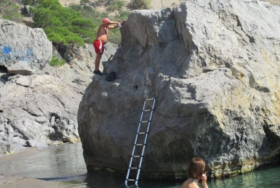 Вооружившись стремянкой, мужчина начал сверлить скалу в море. Фото: "Подслушано в Судаке"
