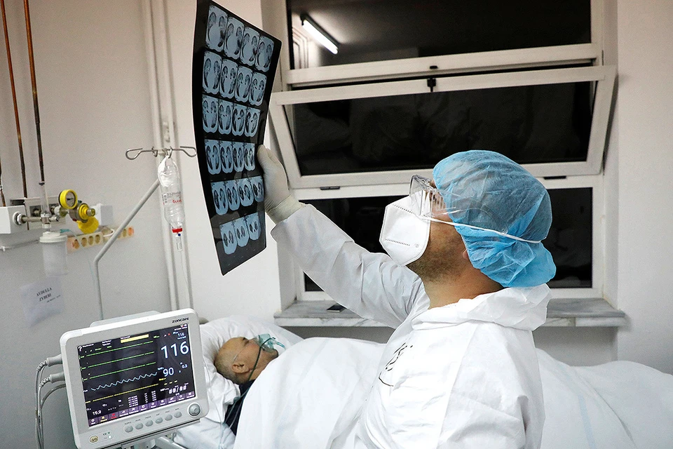 Врач осматривает снимки пациента с коронавирусом.