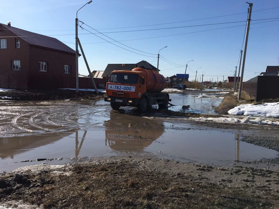 В тюменском Казарово спецмашины откачивают воду с затопленной дороги.