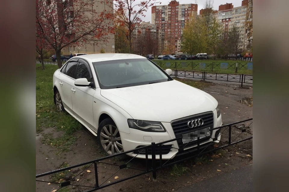 В Петербурге коммунальщики устали ждать, когда водитель уберет машину с газона и обнесли ее забором. Фото: vk.com/primorsky.online