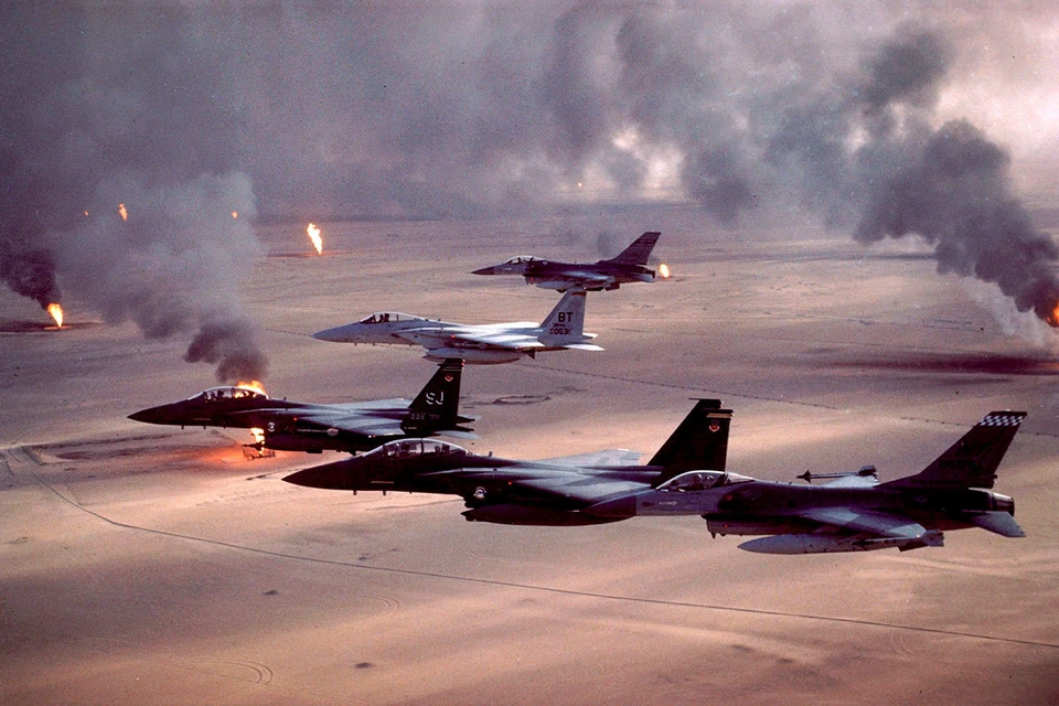 Американские истребители пролетают над горящими нефтяными месторождениями Кувейта во время операции "Буря в пустыне" в 1991 году.