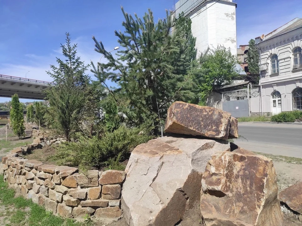 Клумбы, в которых высажены елочки и кипарисы, аккуратно выложены камнями поменьше.