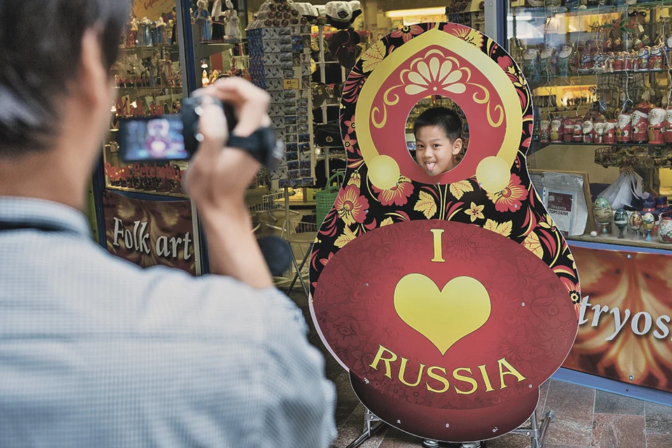 Китайские туристы с удовольствием фотографировали своих детей с тем, что для всего мира являлось символами России - матрешками и кокошниками.