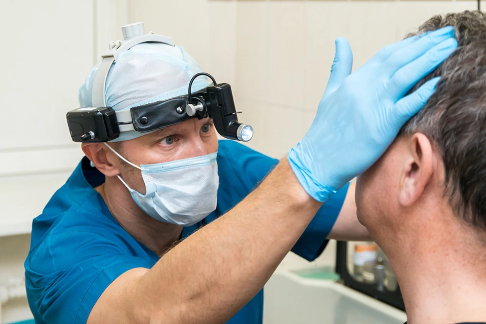 Дмитрий Сергеевич Алексеенко, заведующий оториноларингологическим отделением, проводит осмотр пациента после эндоскопической синус-операции. Фото: «РЖД-Медицина»