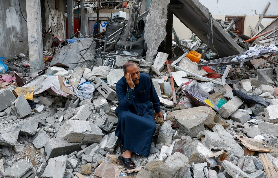 Палестинец у руин разрушенного дома в Газе.