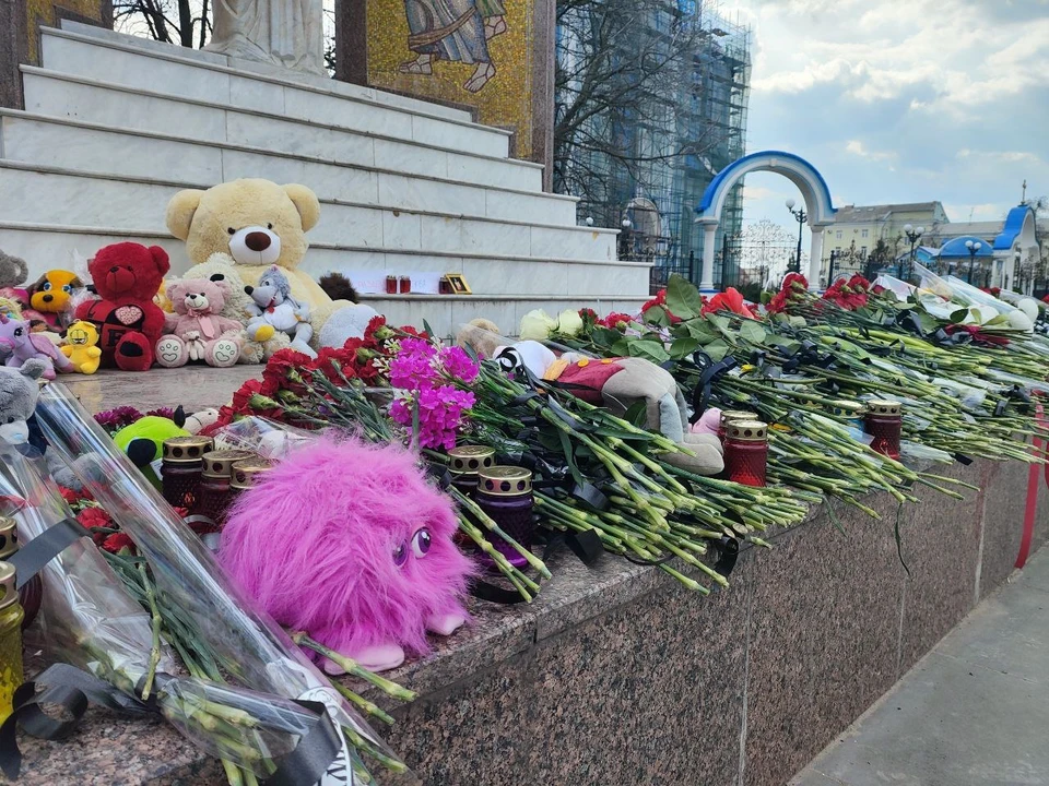 Жители несут к мемориалам цветы и игрушки