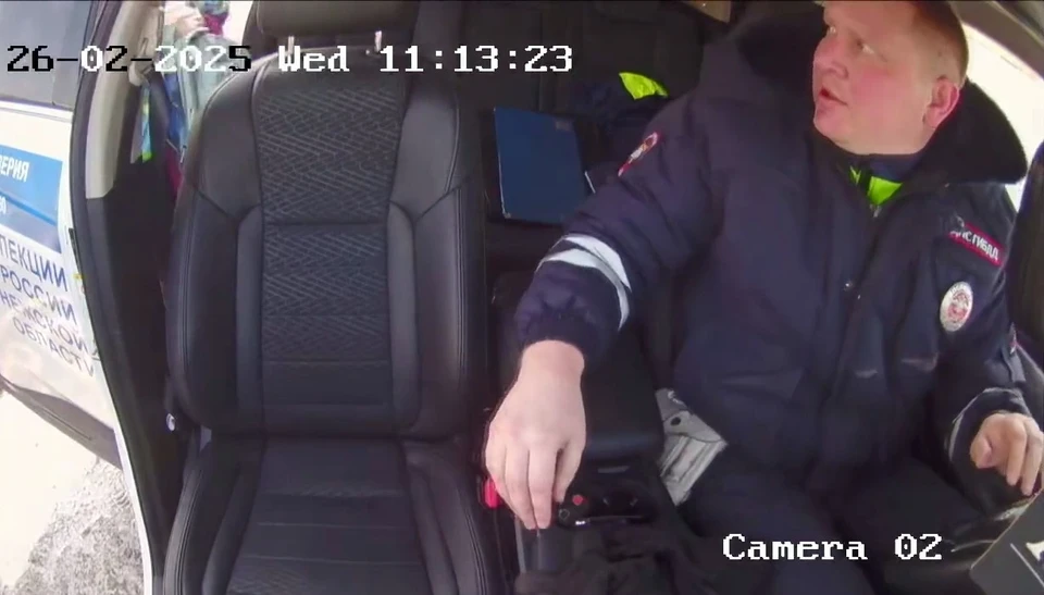 Женщина с грудным ребенком садится в патрульный автомобиль, чтобы доехать до больницы.
