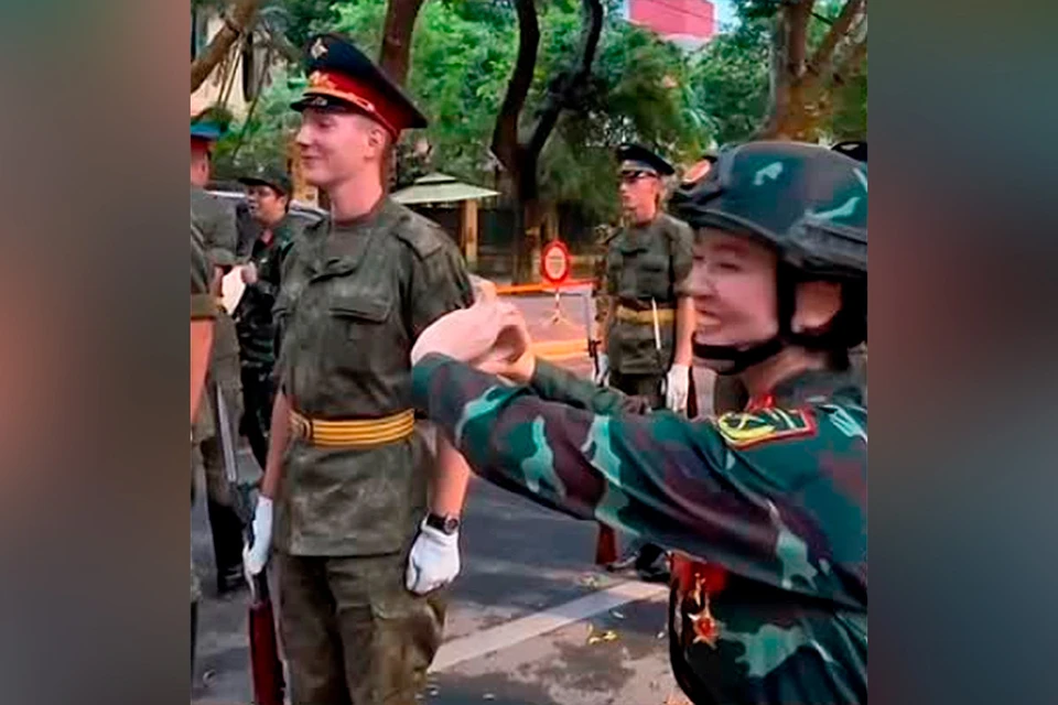 Вьетнамская военнослужащая заигрывает с русским военнослужащим, который прибыл в Ханой.