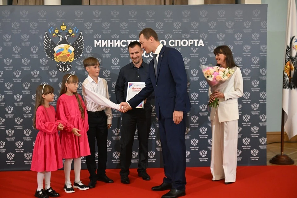 Министр спорта Михаил Дегтярев вручает заслуженные награды победителям конкурса — семье Фадеевых.