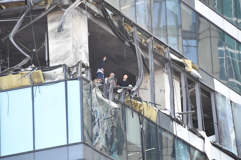 Рабочие восстанавливают фасад здания.