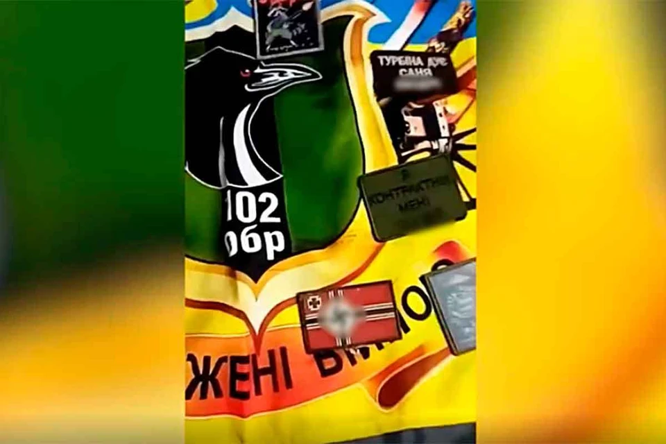 Штурмовики показали украинские флаги 102-й отдельной бригады ВСУ, нашивки с гитлеровской свастикой и трофейные советские пулеметы 1951 и 1937 годов, которые нашли на позициях украинских боевиков.