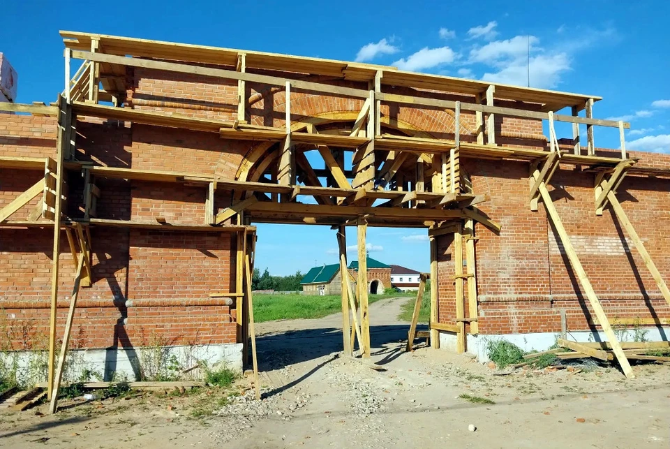 Часть новой стены с входом, через который вдали видно святые старинные врата обители в виде арки. Фото: Александра ШАРОВА