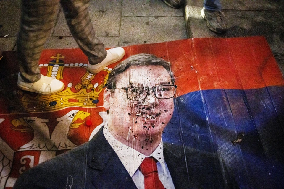 Люди ходят по изображению Александра Вучича, кандидата в премьер-министры от Сербской прогрессивной партии
