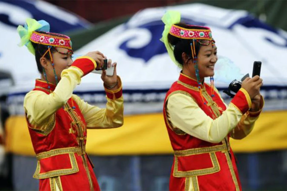 «Зато у нас у всех мобильники!» - с гордостью говорят защитники капитализма и демократии по-монгольски. На фото - девушки в монгольских национальных костюмах.