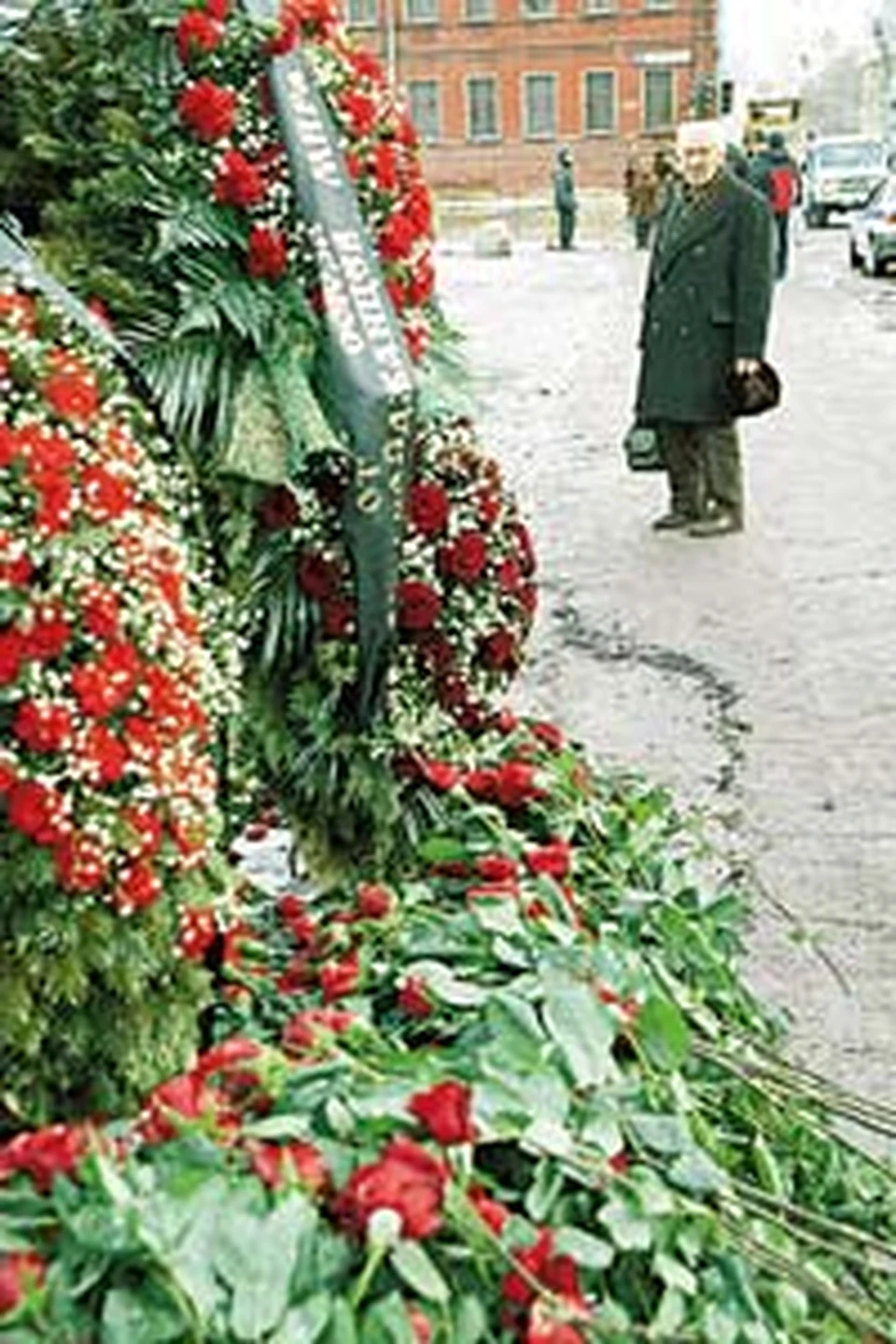 Вокруг руин - тысячи роз и венков. Прохожие крестятся и молятся за упокой погибших.