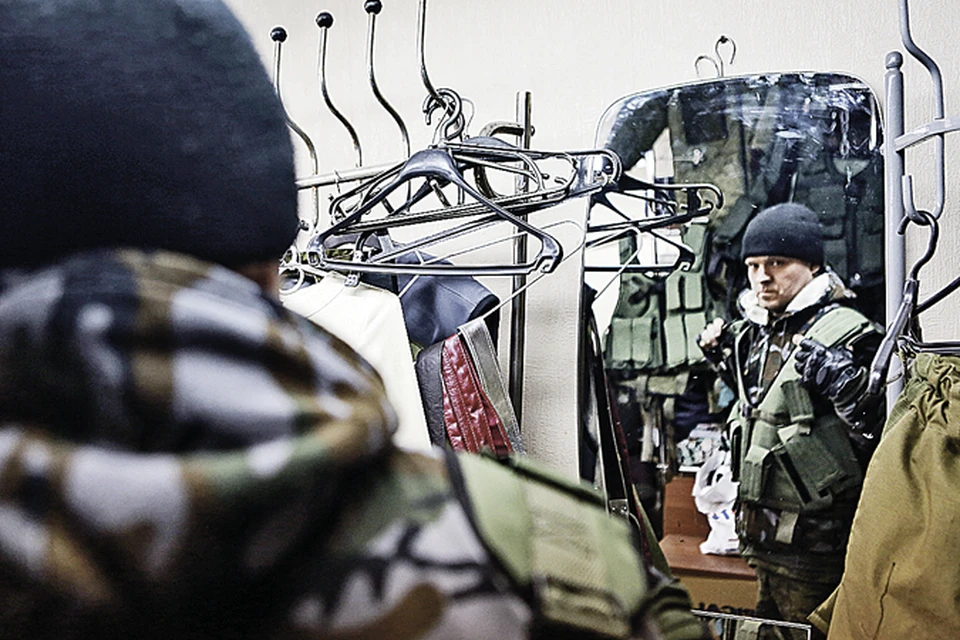 Ополченец ДНР примеряет военную разгрузку в ателье «Барышни», которое переквалифицировалось и теперь шьет для фронта.