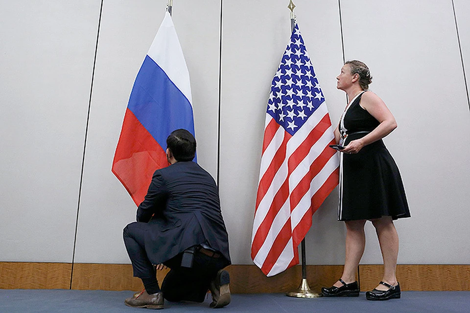 Сотрудники дипломатических ведомств устанавливают флаги перед началом очередного раунда переговоров Сергея Лаврова и Джона Керри.