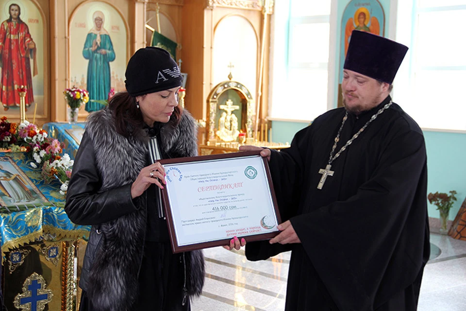 Сертификат на получение денег главе фонда Help the Children-SKD Елене Коневой вручил отец Андрей.